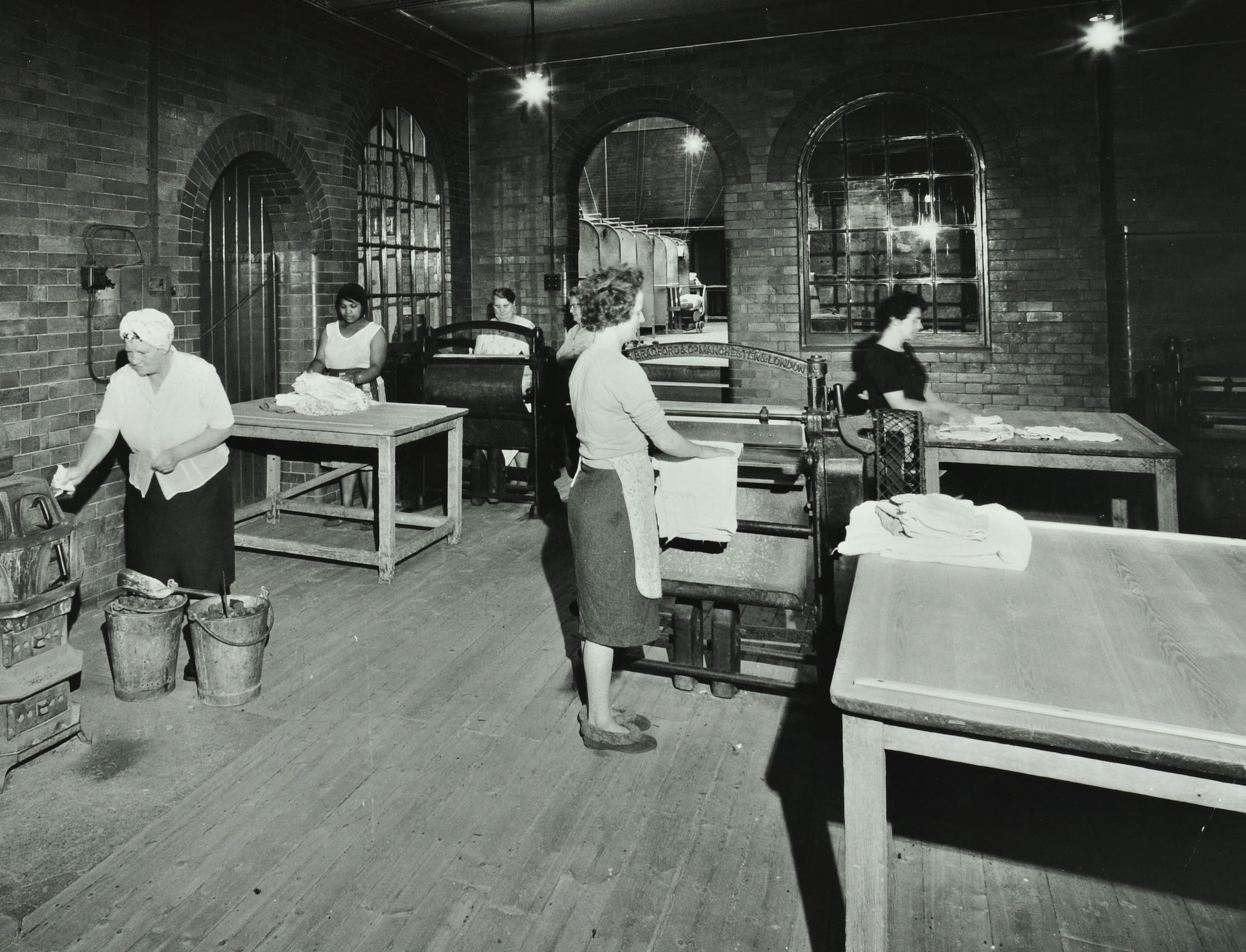 a laundry room with a mangle and buckets
