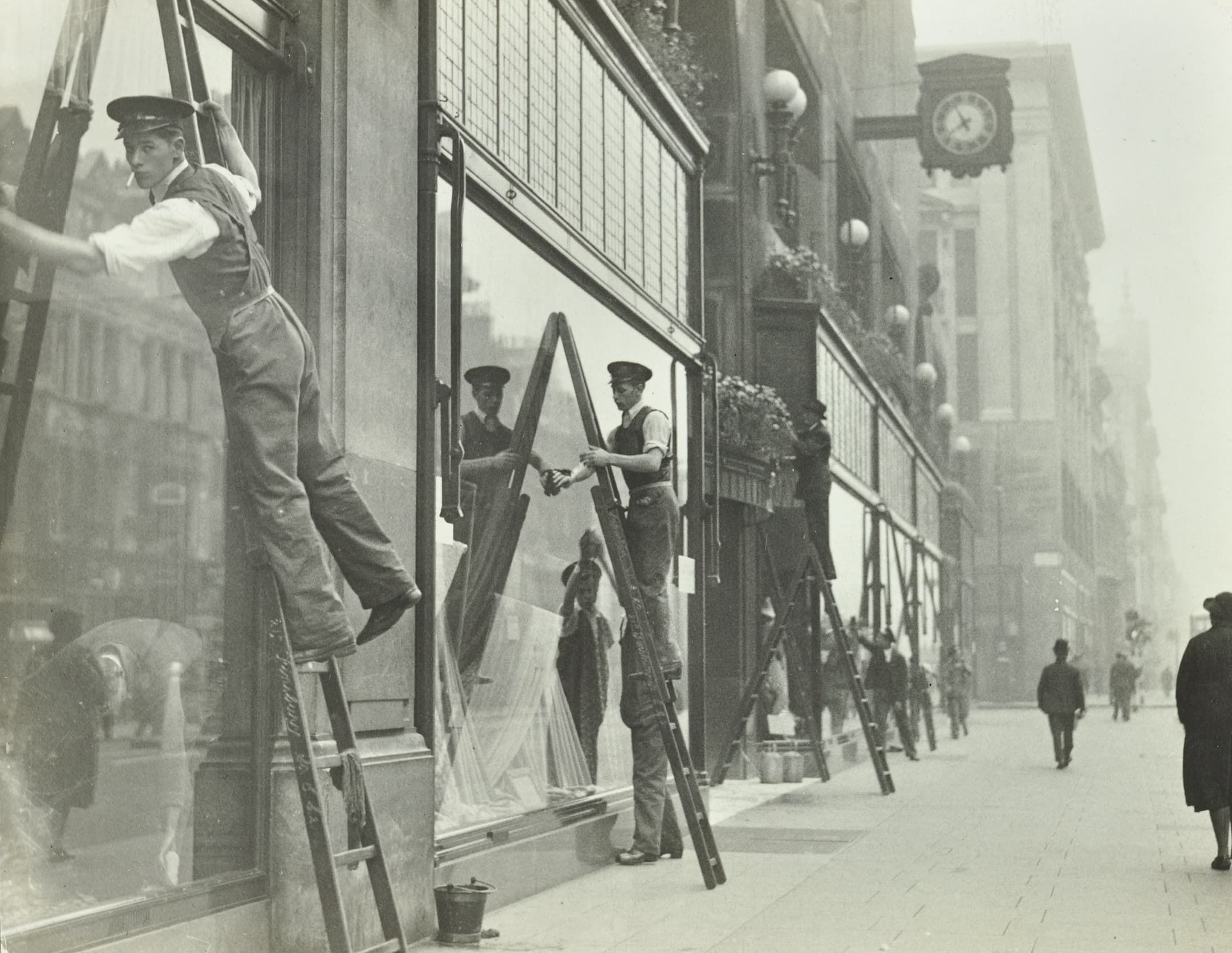 window cleaners up ladders cleaning large shopfront windows