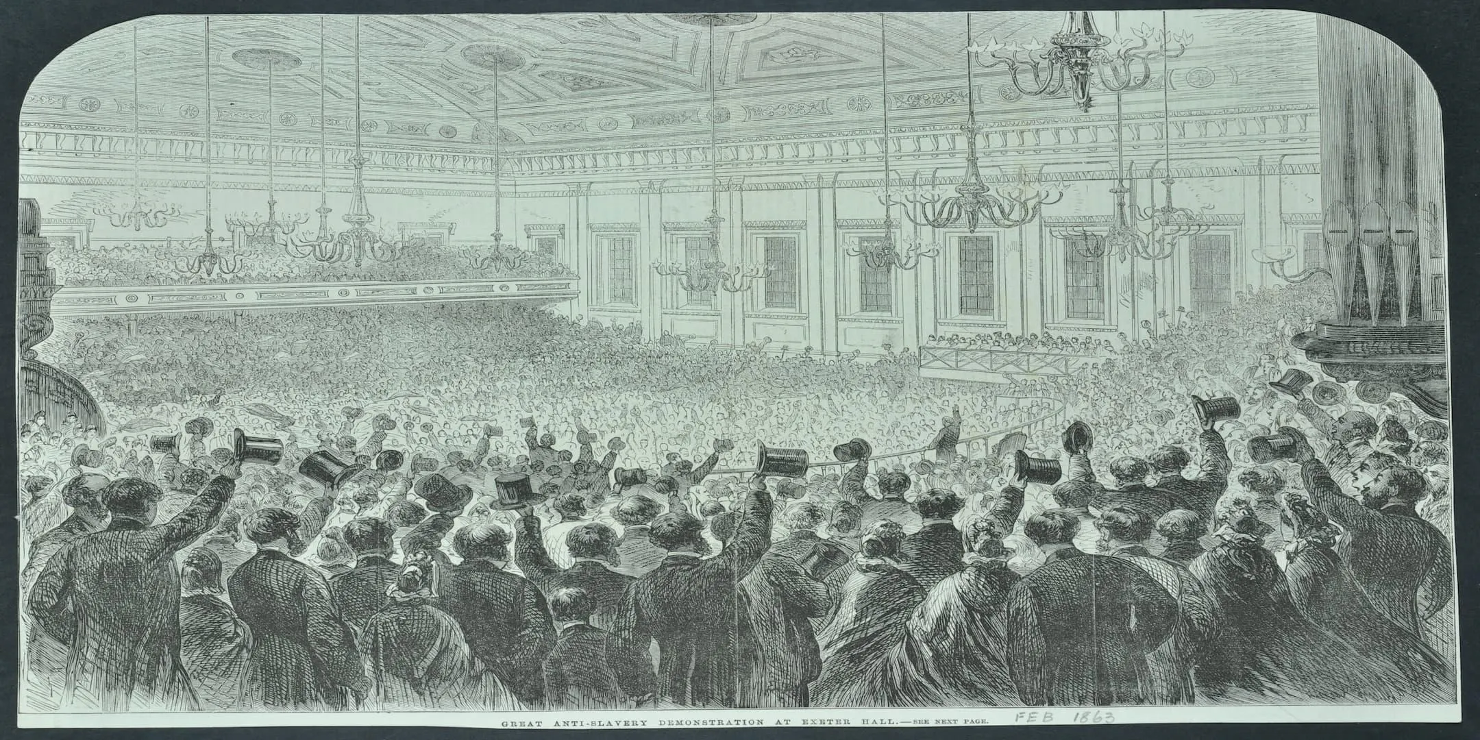 A packed hall with men waving their top hats in the air