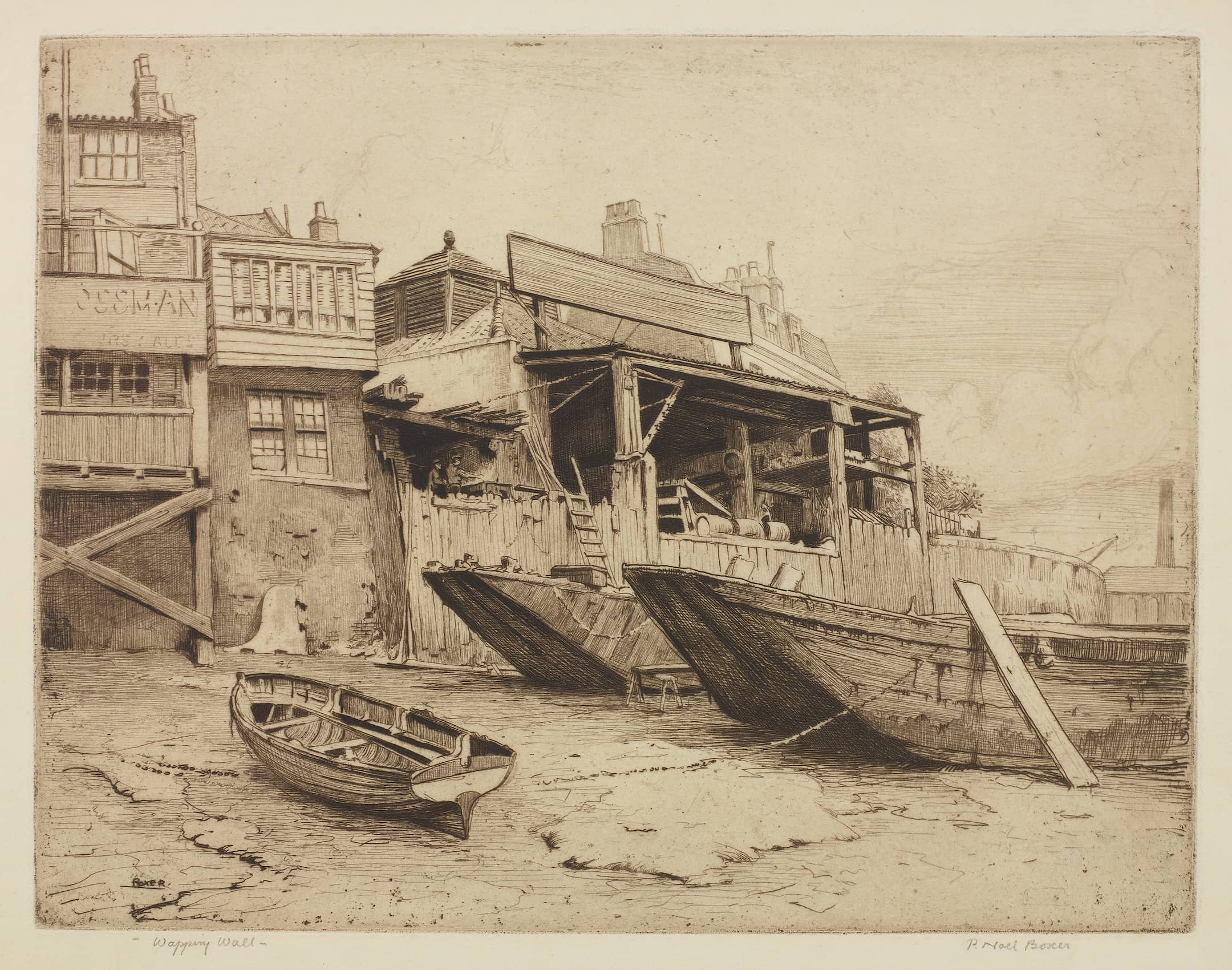barges in the mud on the foreshore next to riverside buildings