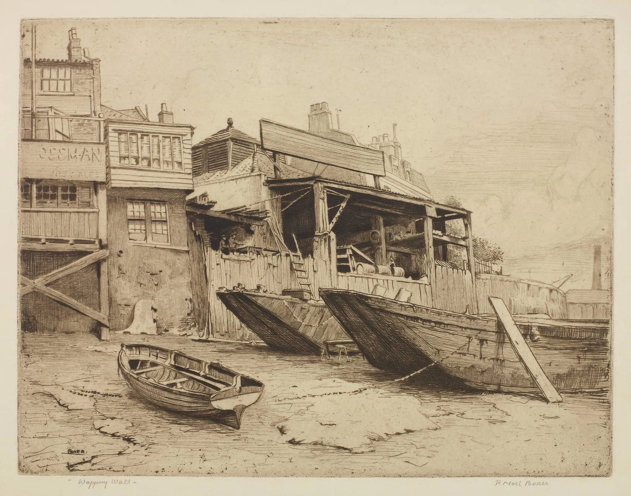 barges in the mud on the foreshore next to riverside buildings