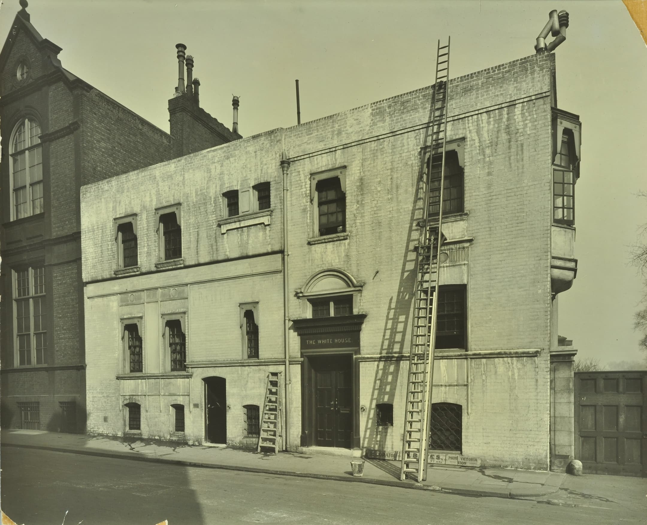 a white house with ladders propped against the building