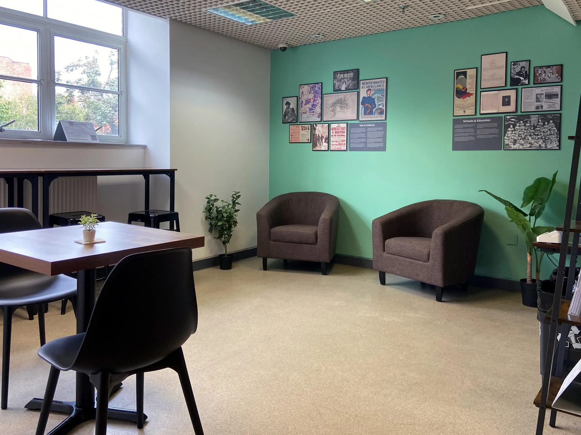 Armchairs and a display of images on the wall in the Visitor Lounge at The London Archives.