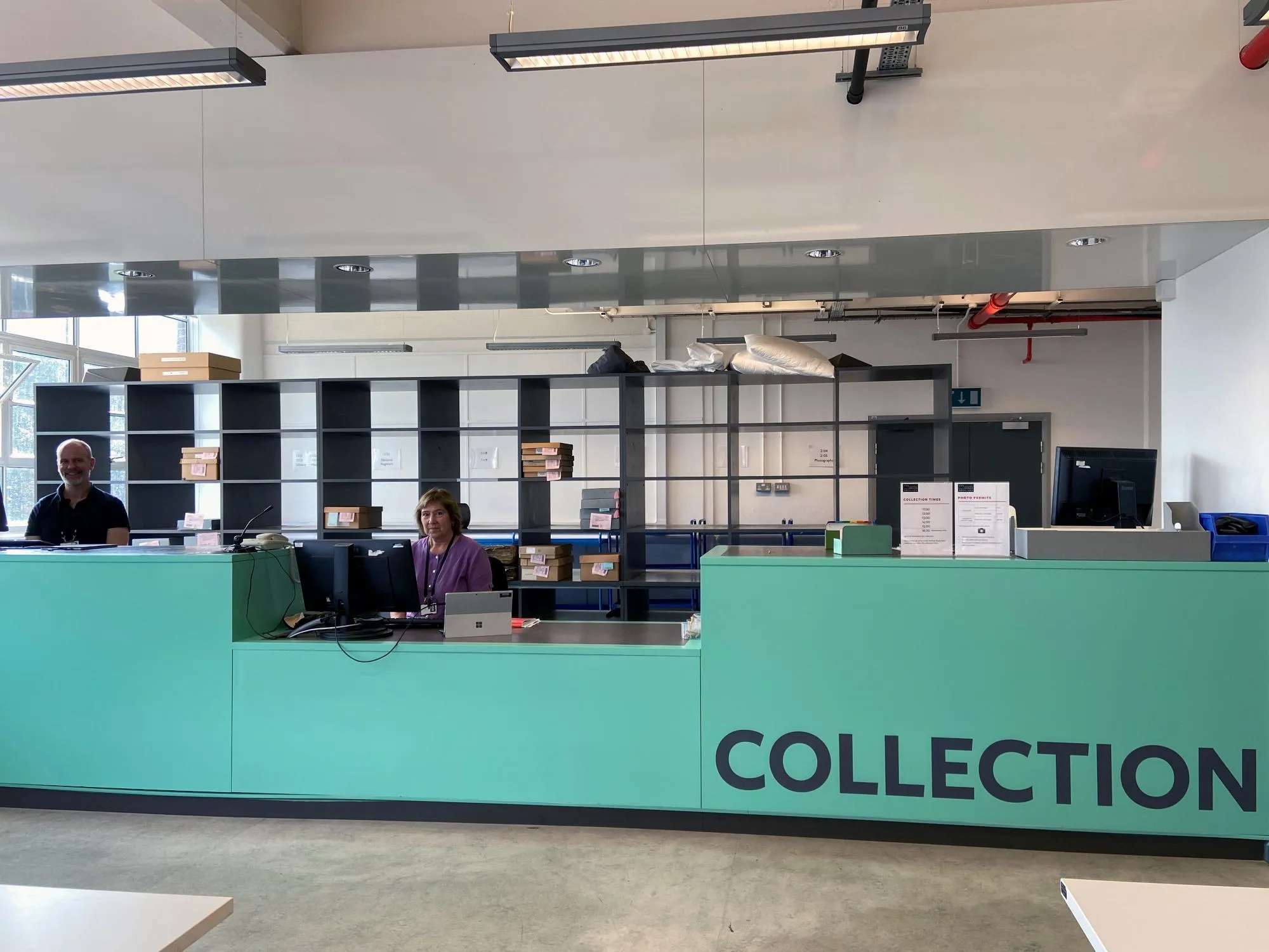 Two people seated at the Collection Point at The London Archives.