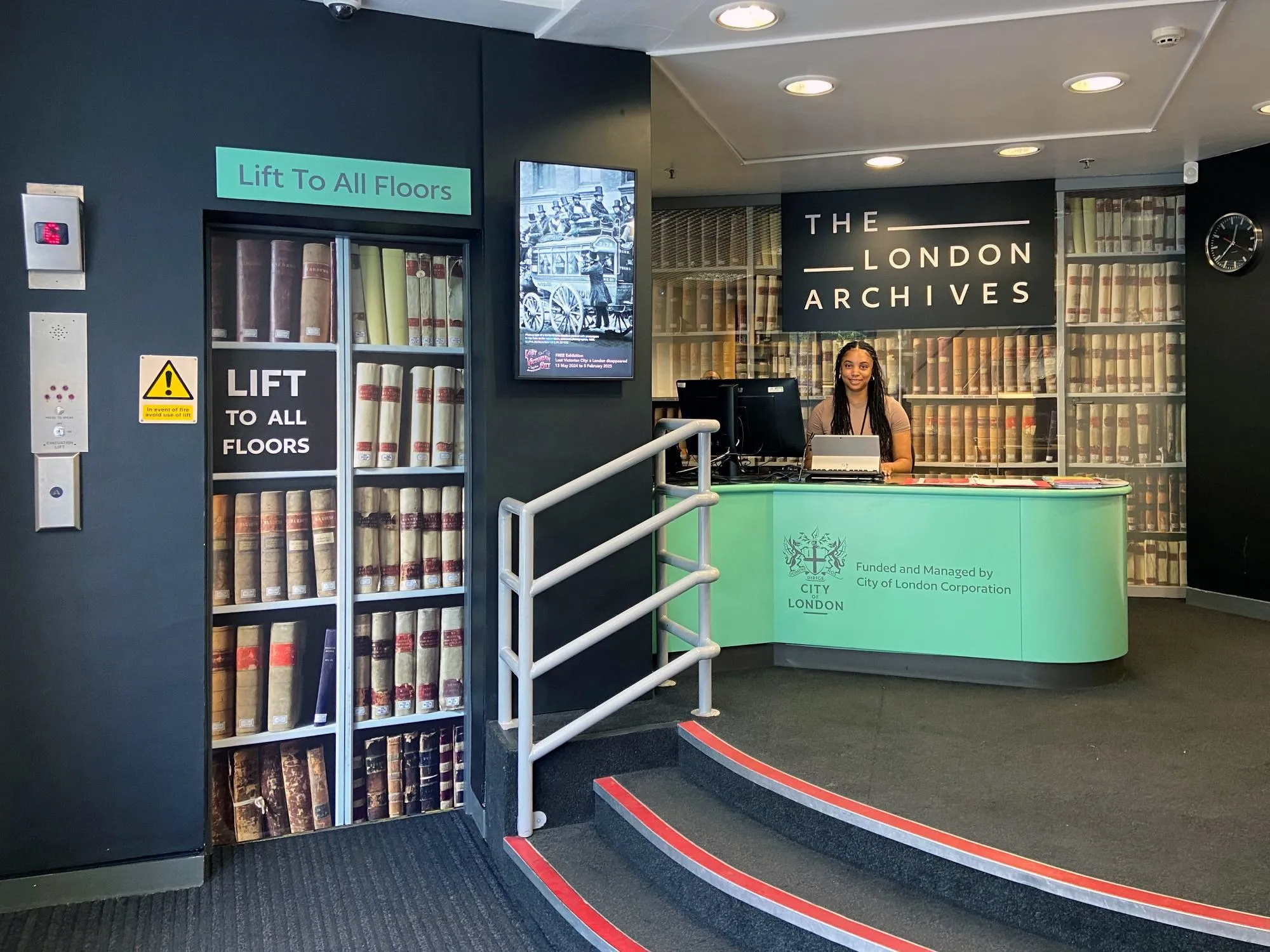 A person seated in the Welcome Area at the main entrance to The London Archives.