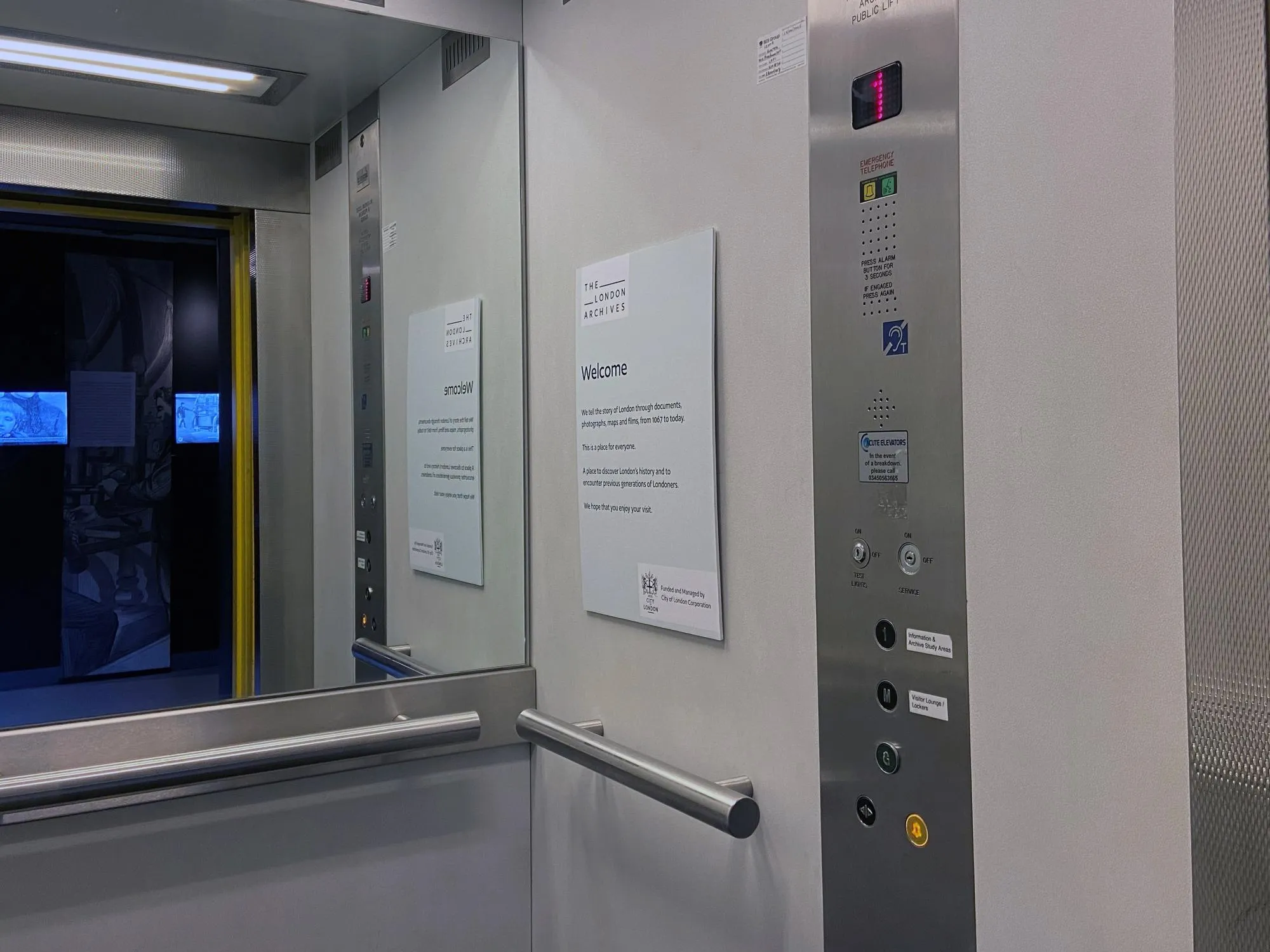 Interior of the public lift at The London Archives including control buttons and mirror.