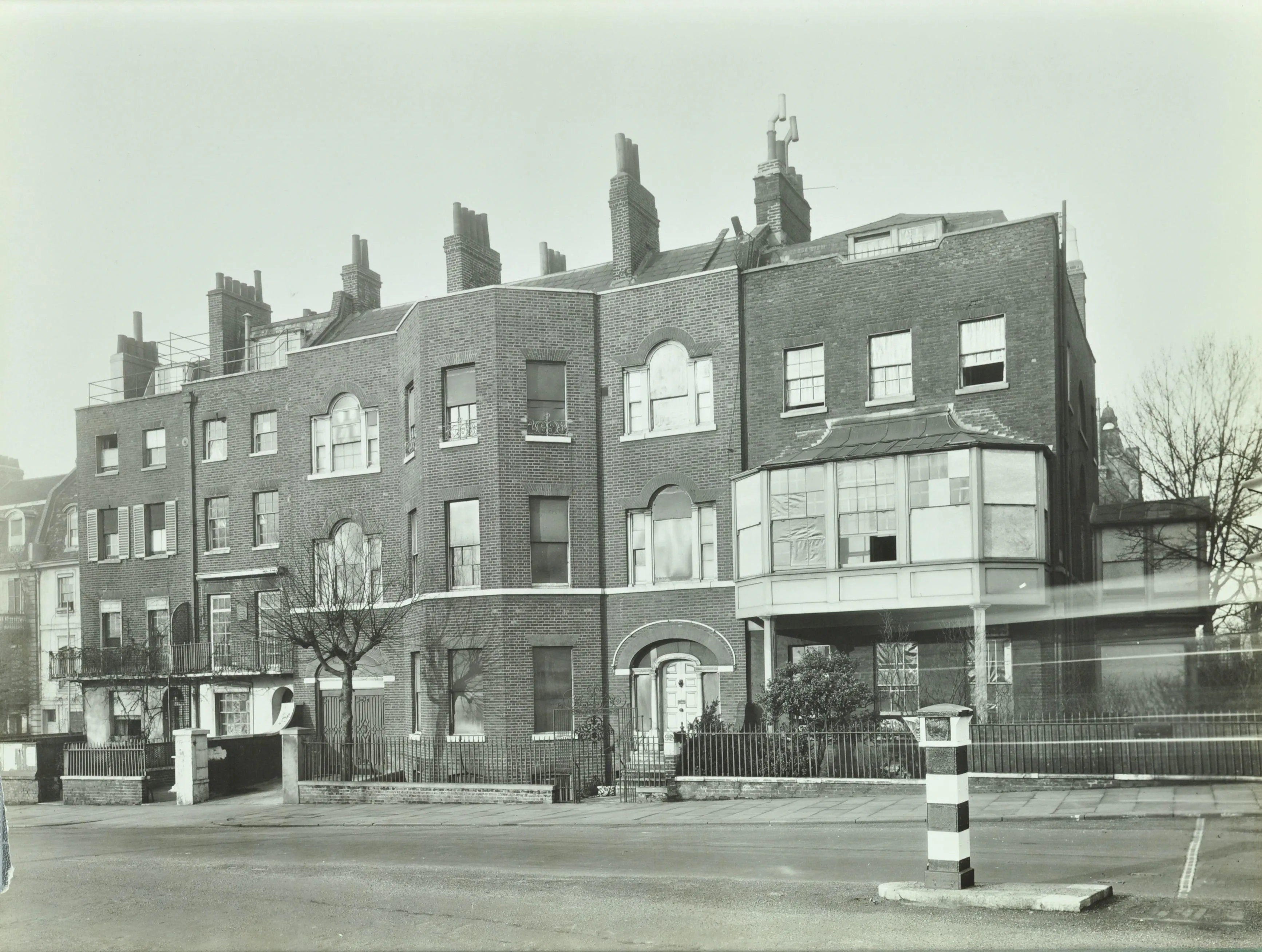 A row of three storey houses with the glass boarded up