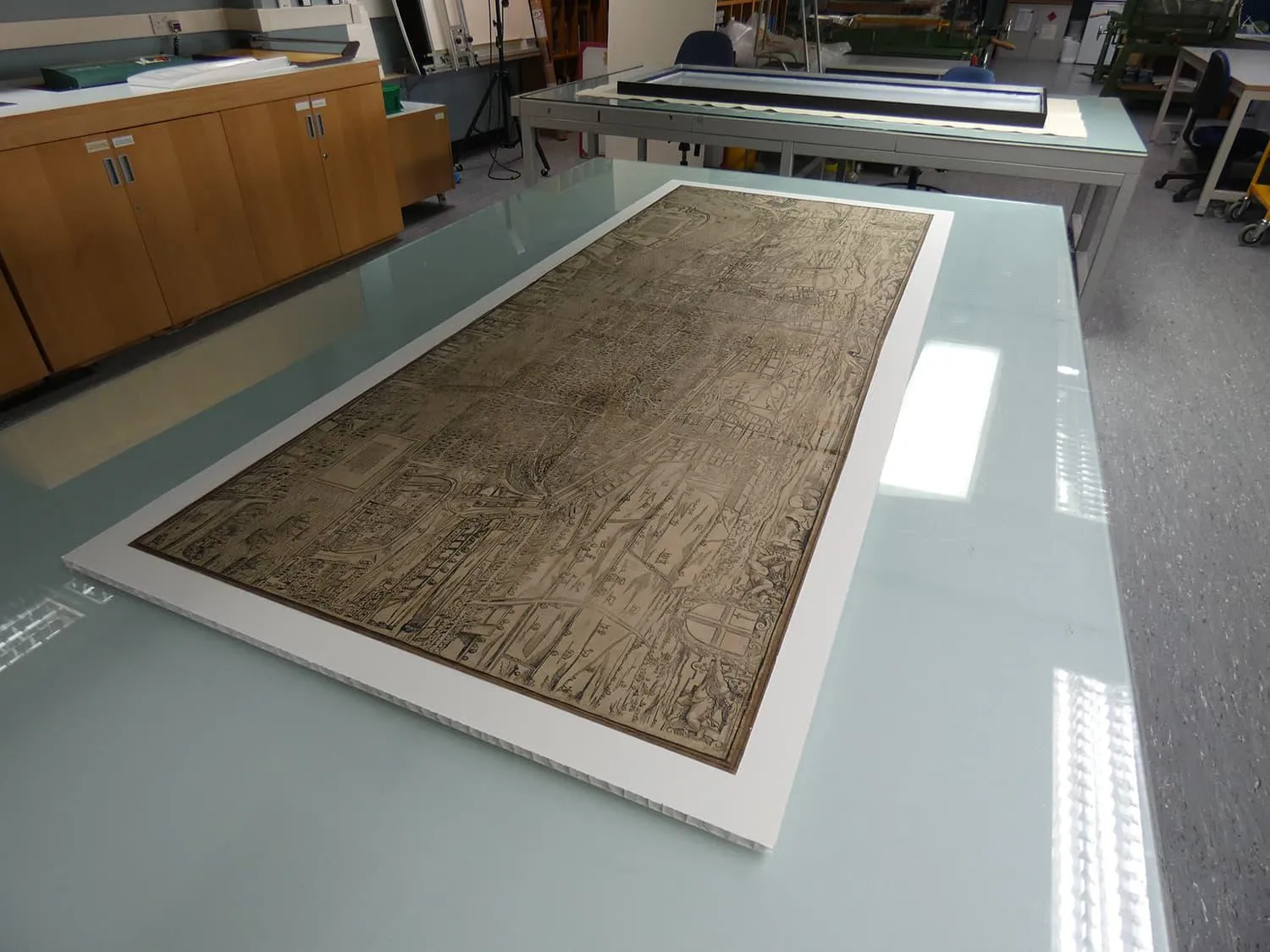 Map laid flat on a table and fixed to a mounting panel underneath it