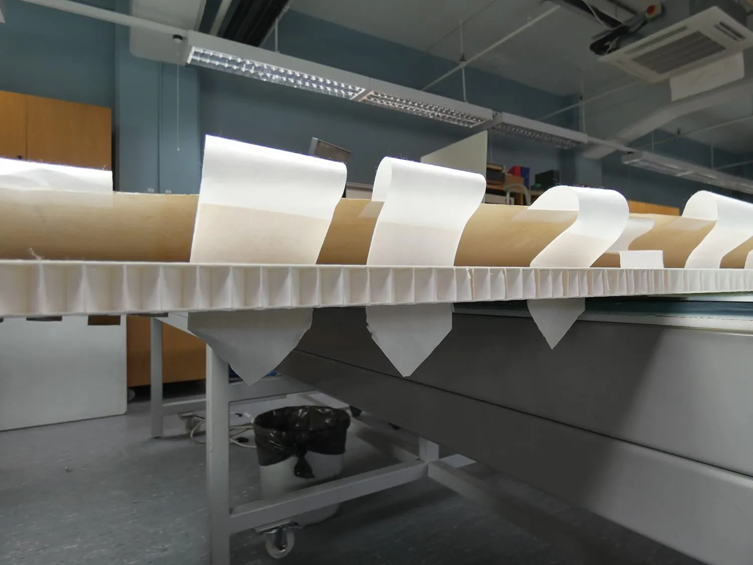 Paper tabs being used to attach a map to a backing panel