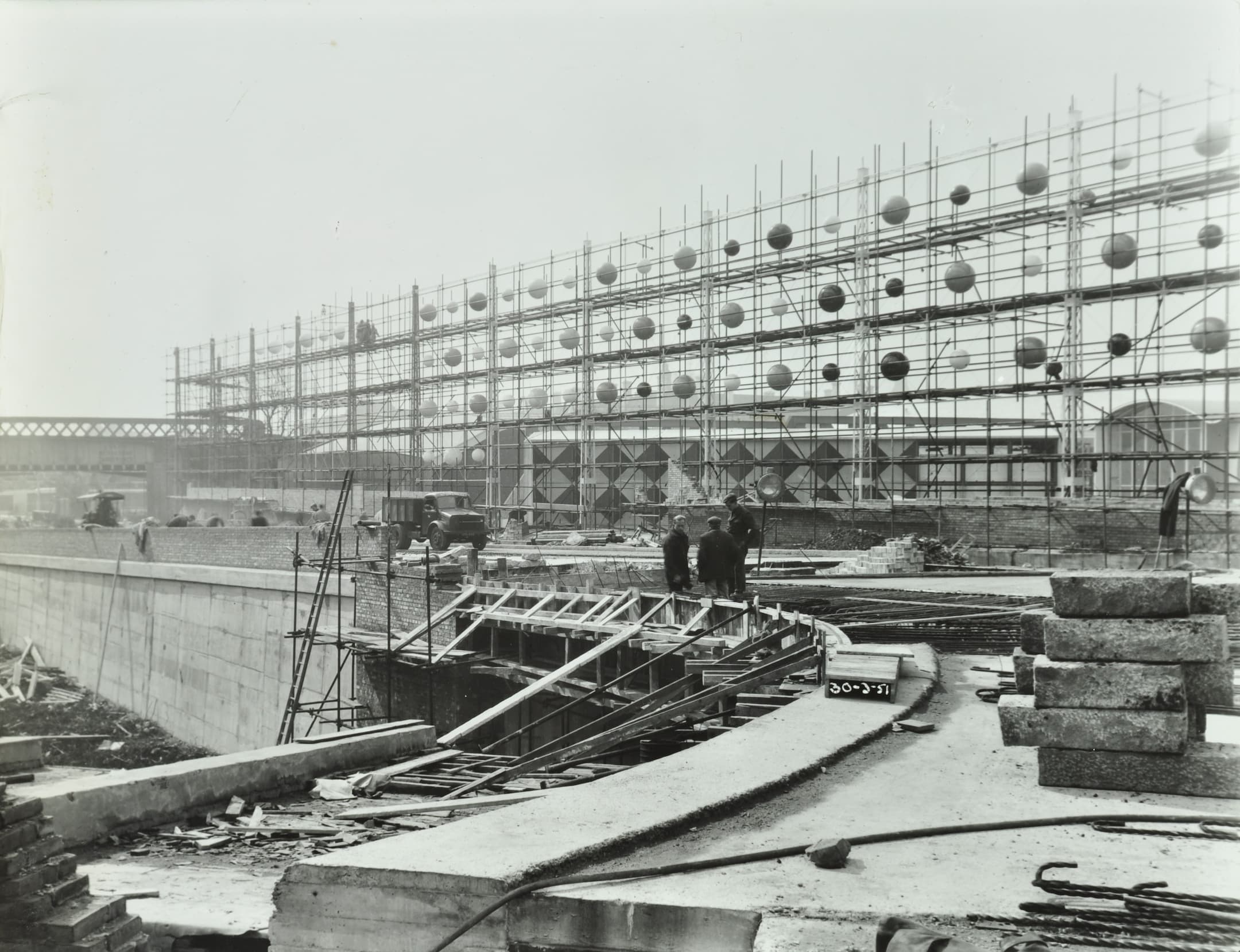 a building site with a metal structure and large spheres floating on them