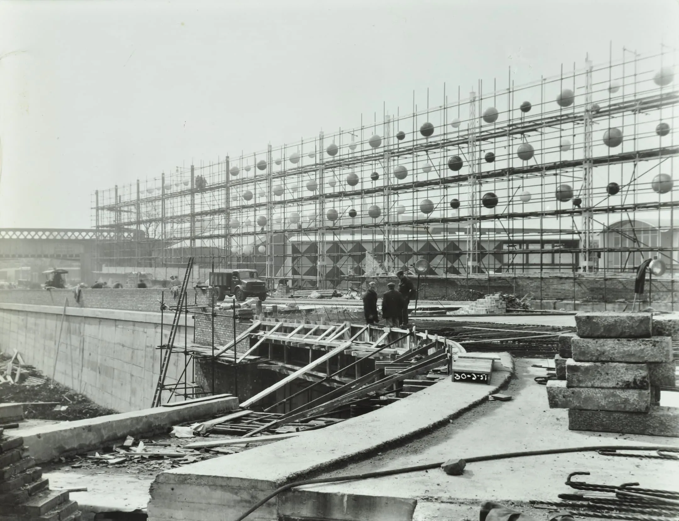 a building site with a metal structure and large spheres floating on them