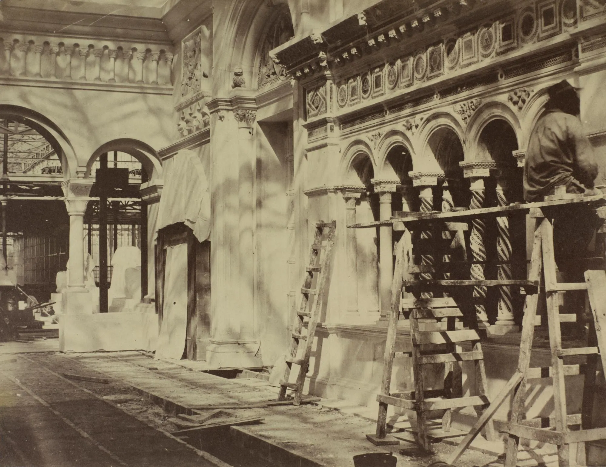 Early photograph showing a worker on scaffolding completing mosaic work at the Crystal Palace