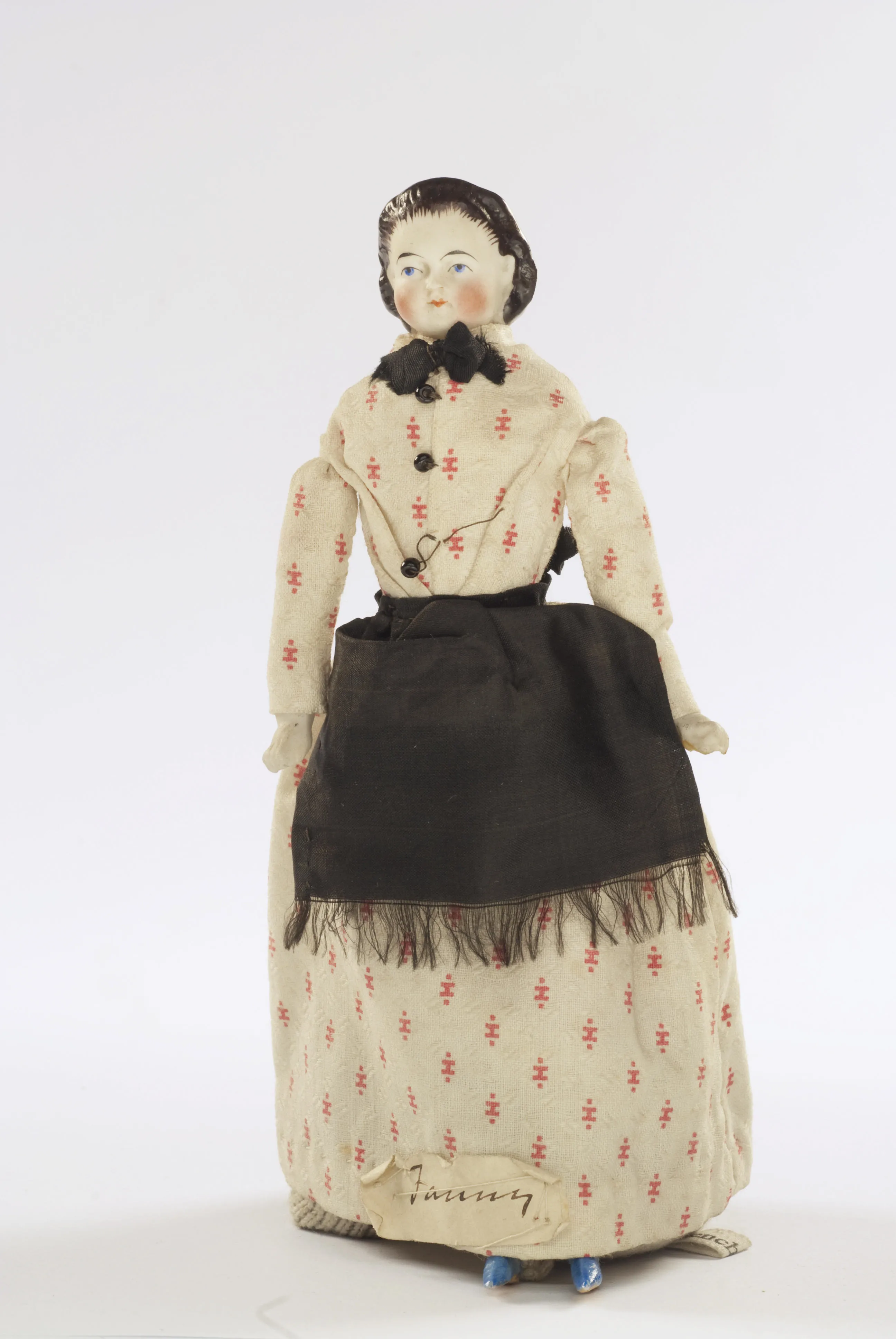 A Victorian doll in housekeeper clothing with an apron
