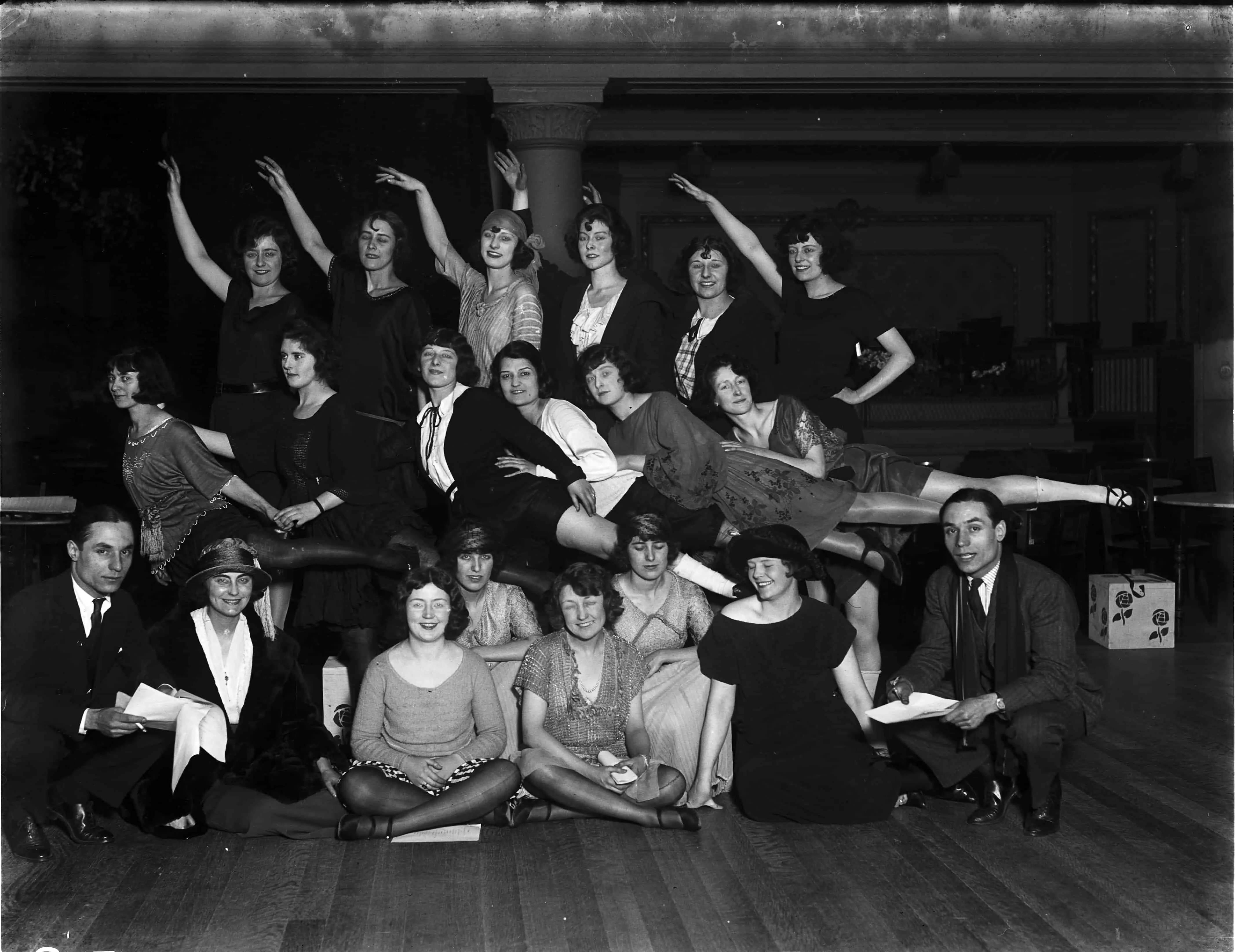 Group portrait of a drama troupe posing theatrically for the camera.