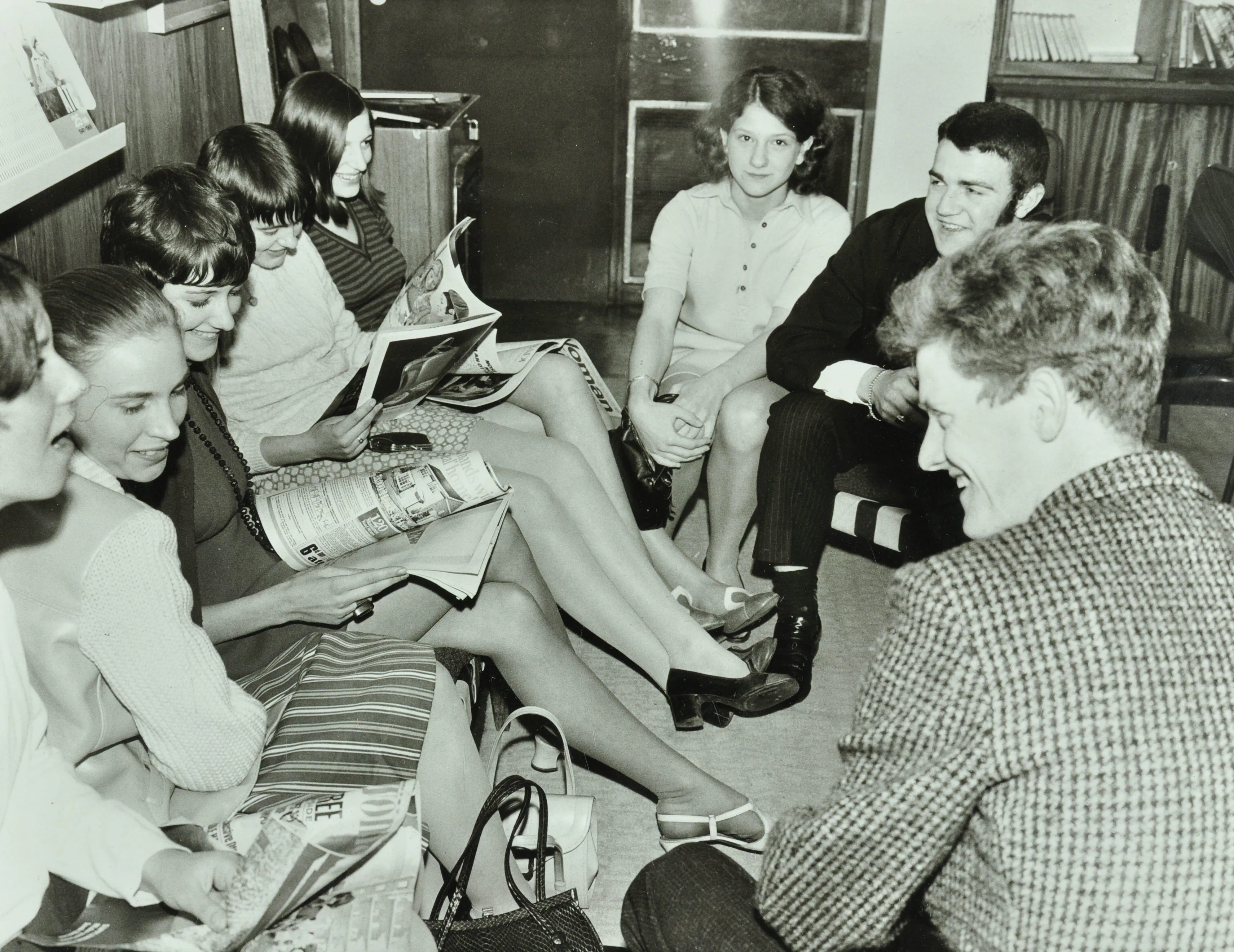 young people seated around reading magazines and chatting