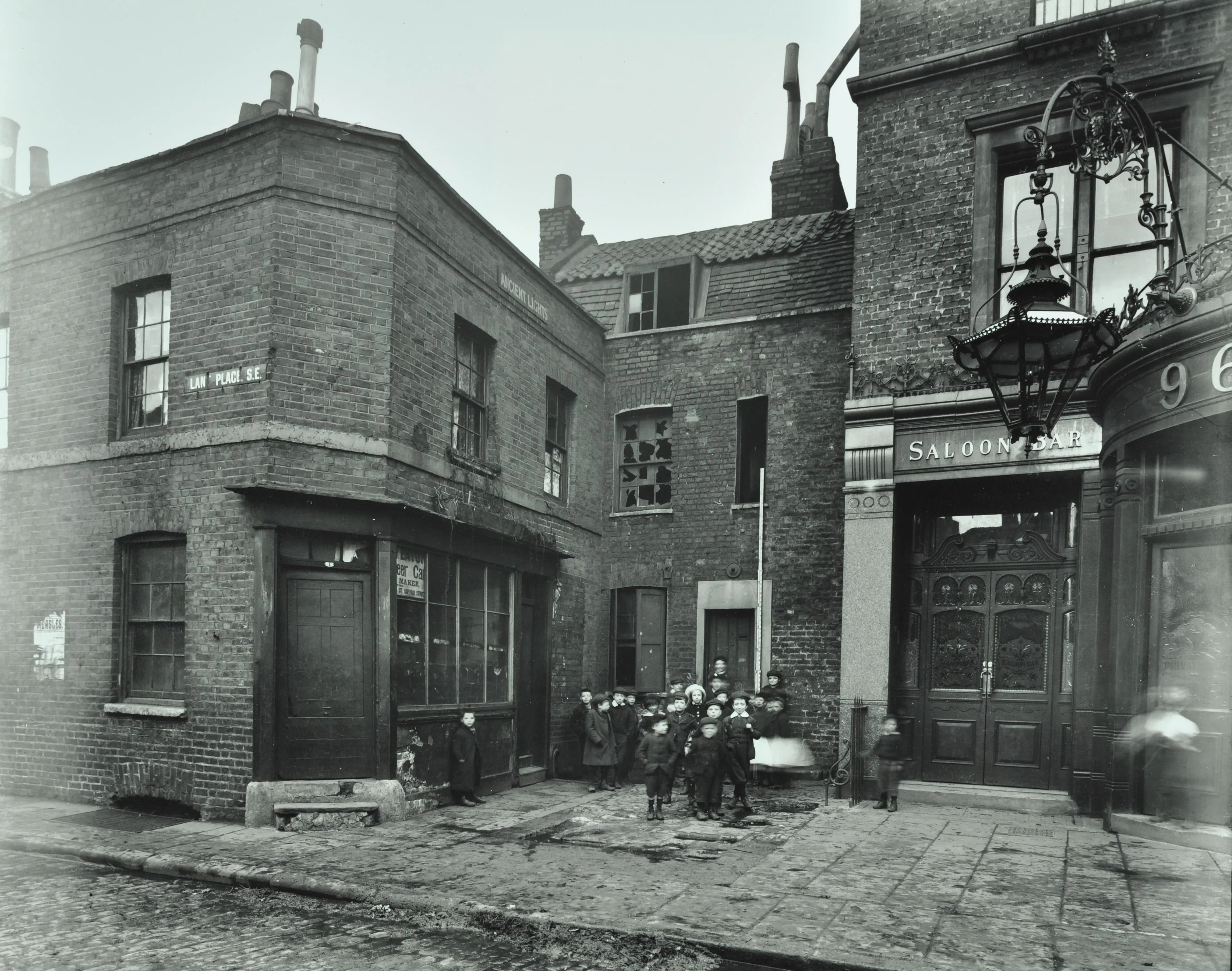 children outside a deteriorated building and saloon bar.