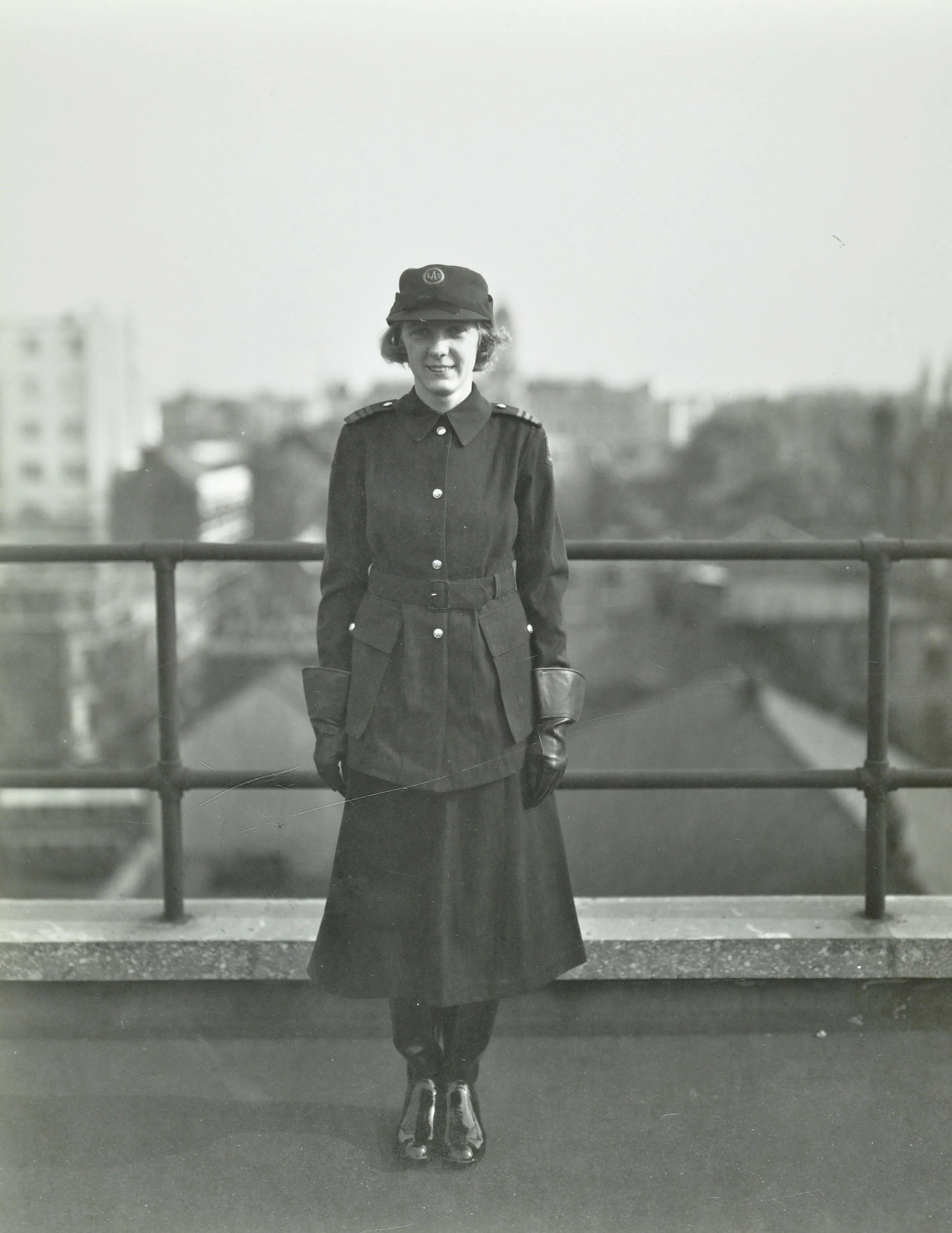 a woman in an Air Raid Precaution outfit stands facing the camera