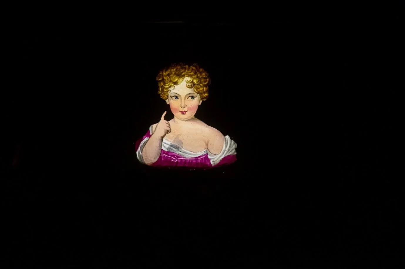 a girl in a pink dress and curly hair points