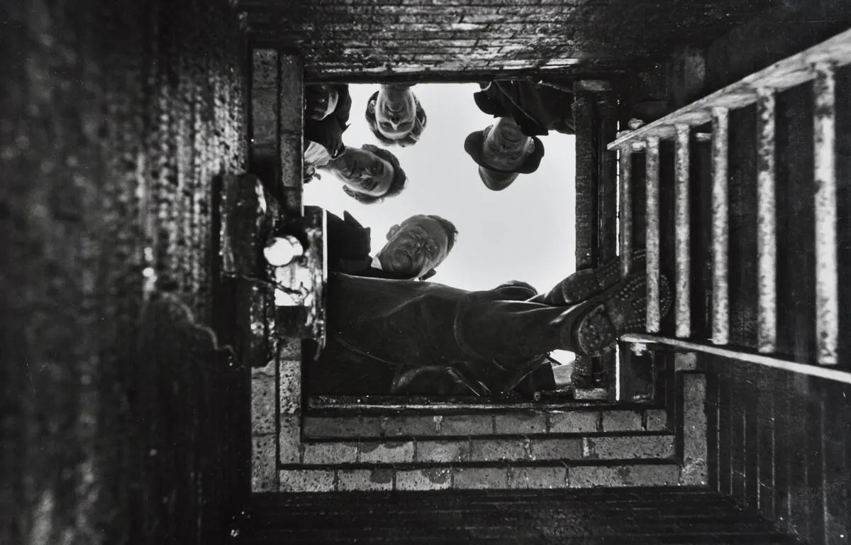 men-looking-down-sewer