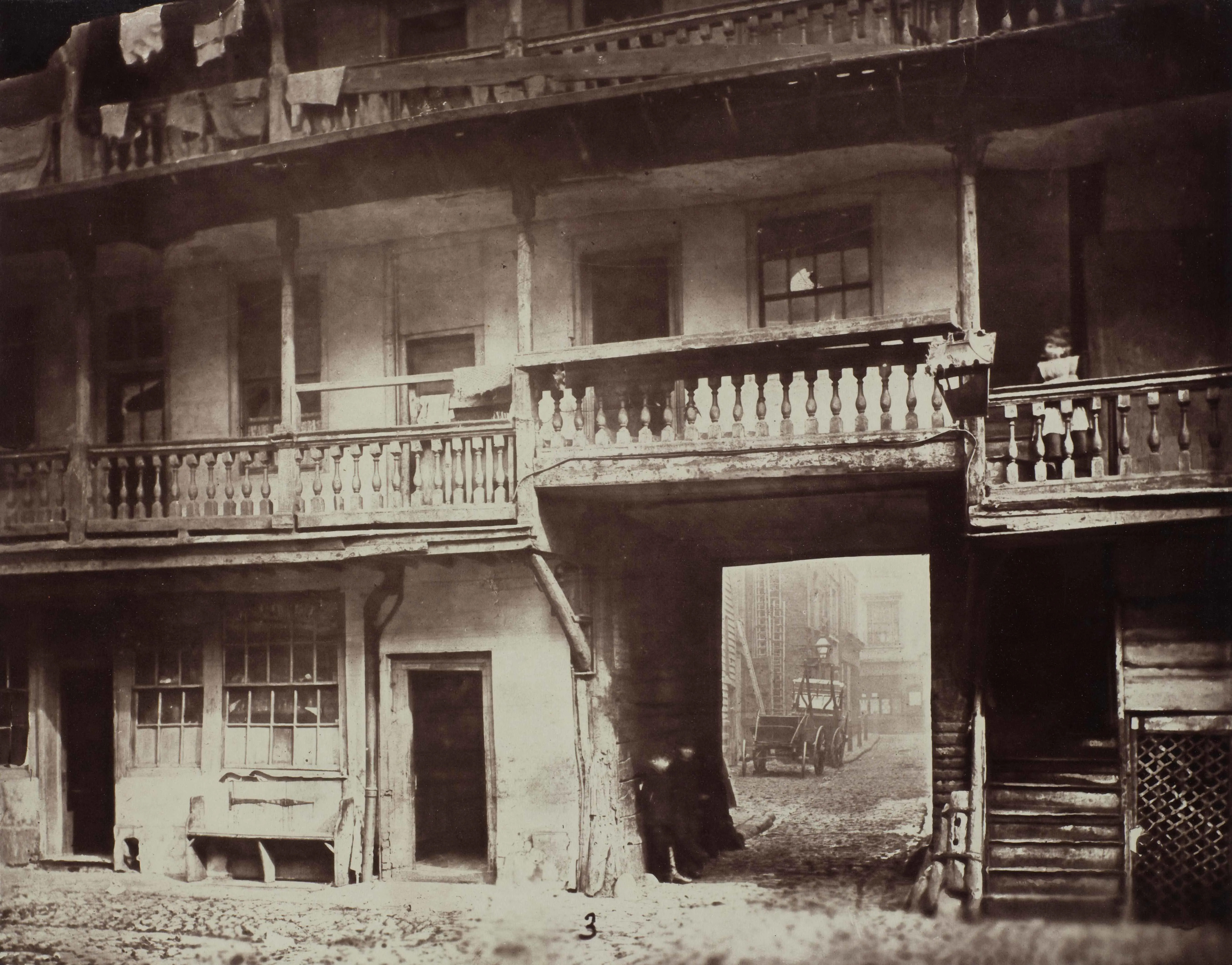 photograph of the entrance to a galleried inn with two people in the doorway