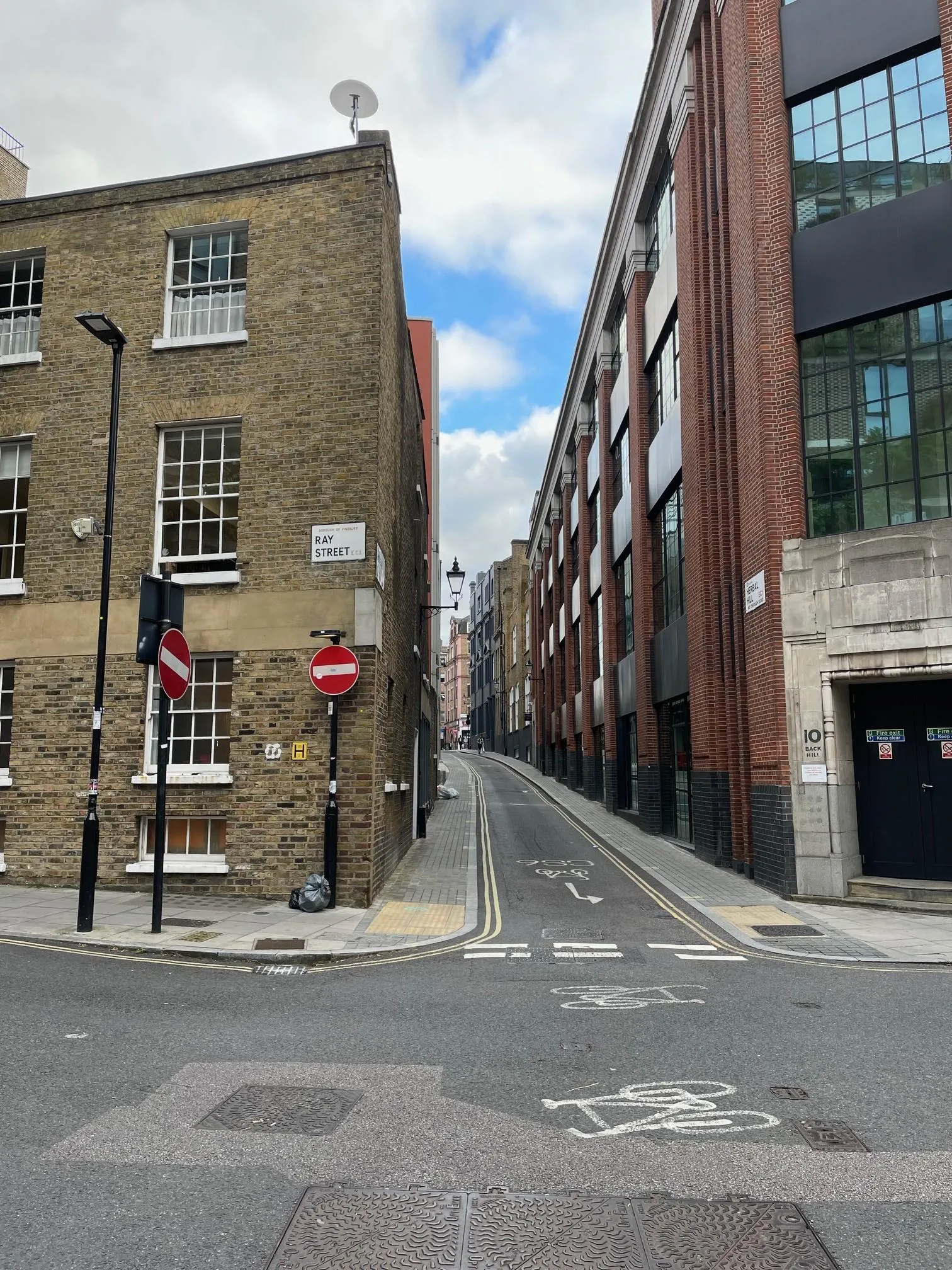 Looking down a narrow street by the junction of a road with no entry signs