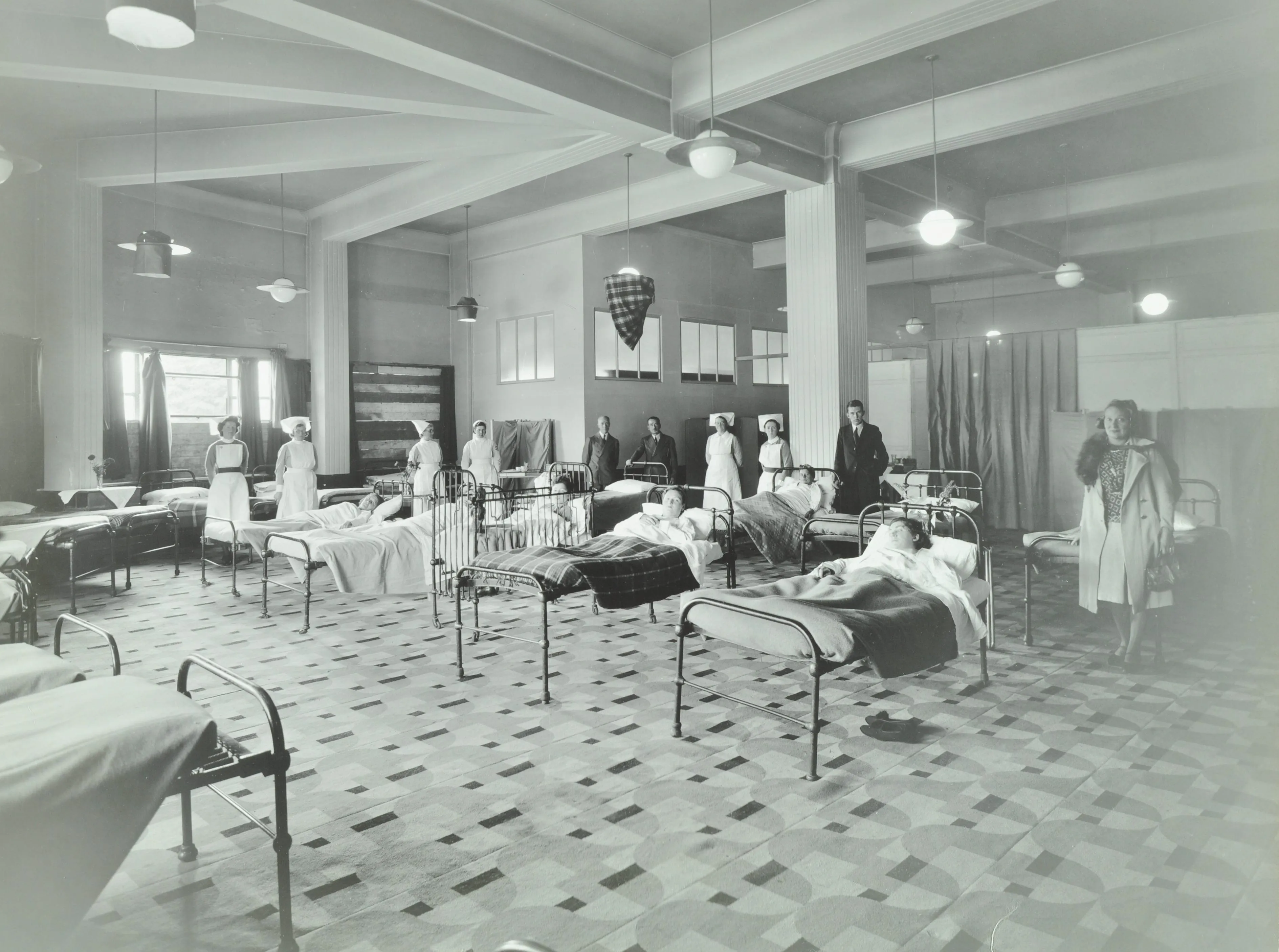 A ward with nurses lined up and patients in beds