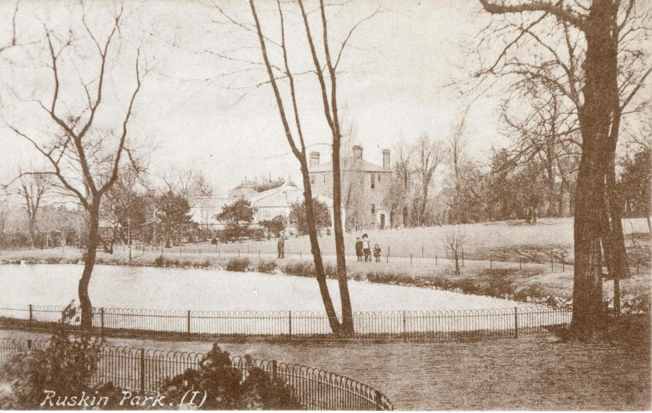 View of Ruskin Park, Camberwell with children walking around the lake, 1900
