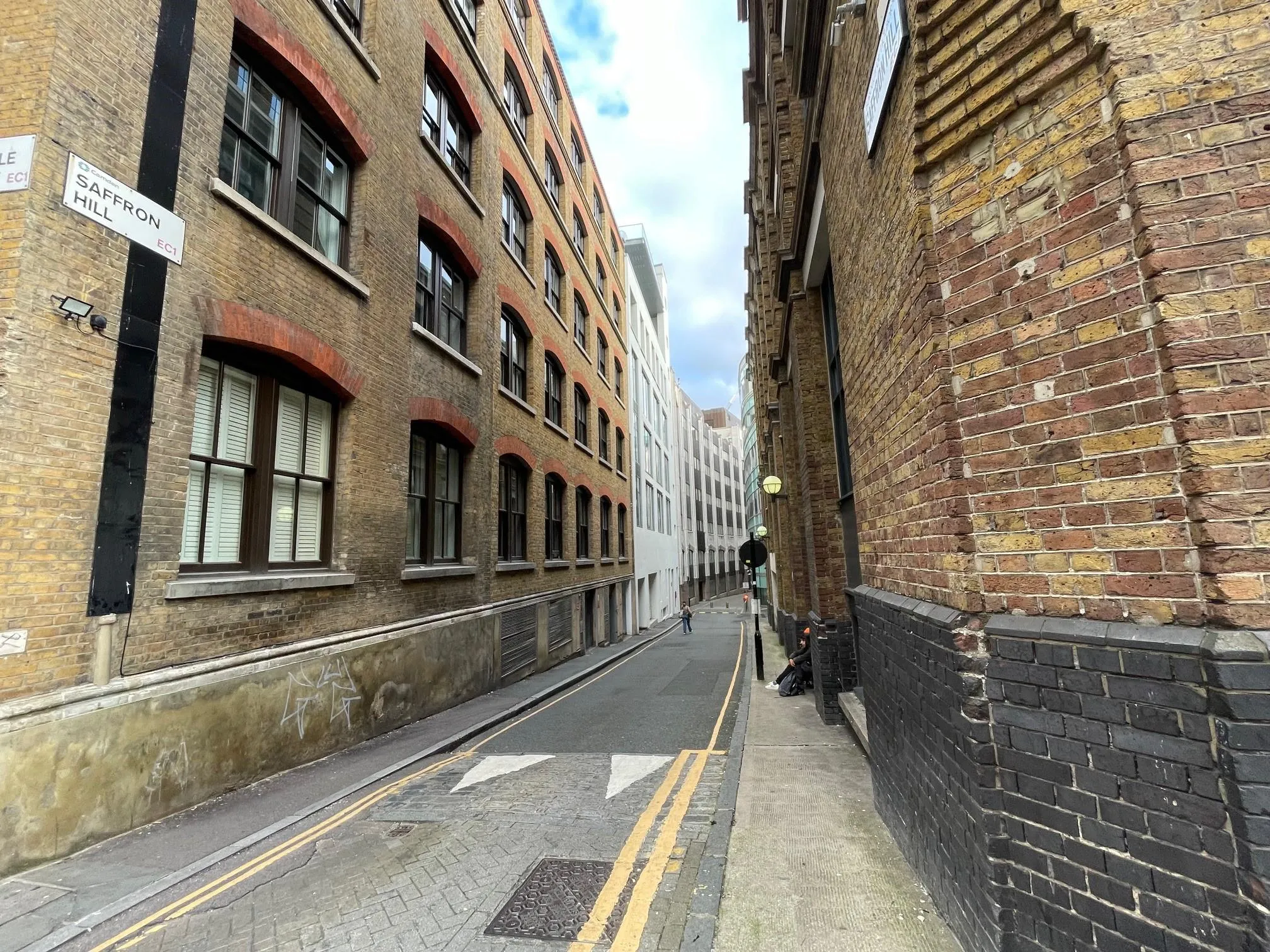 looking down a narrow street with tall buildings either side