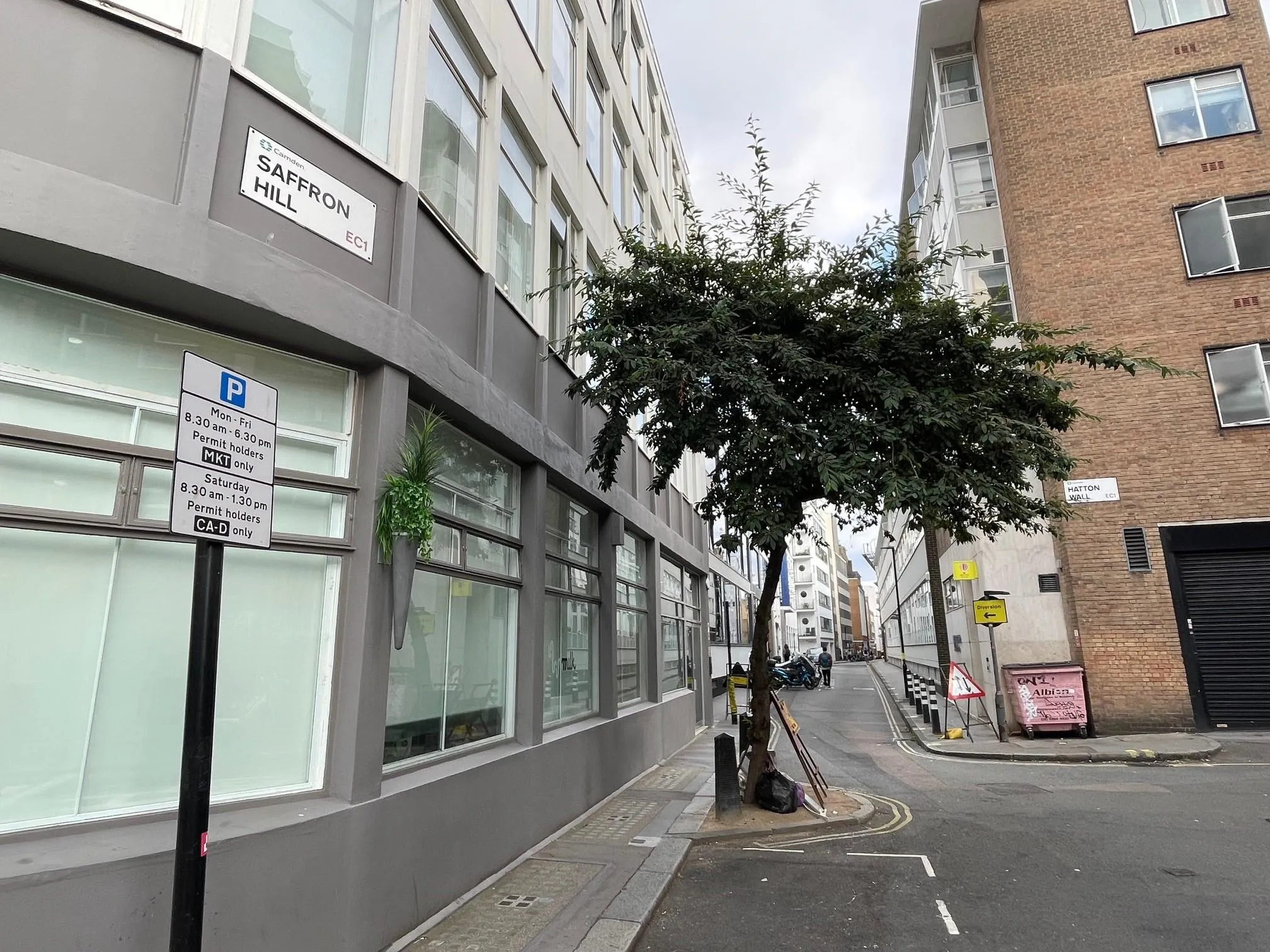 Looking past buildings at Saffron Hill to Hatton Wall with a tree in the foreground