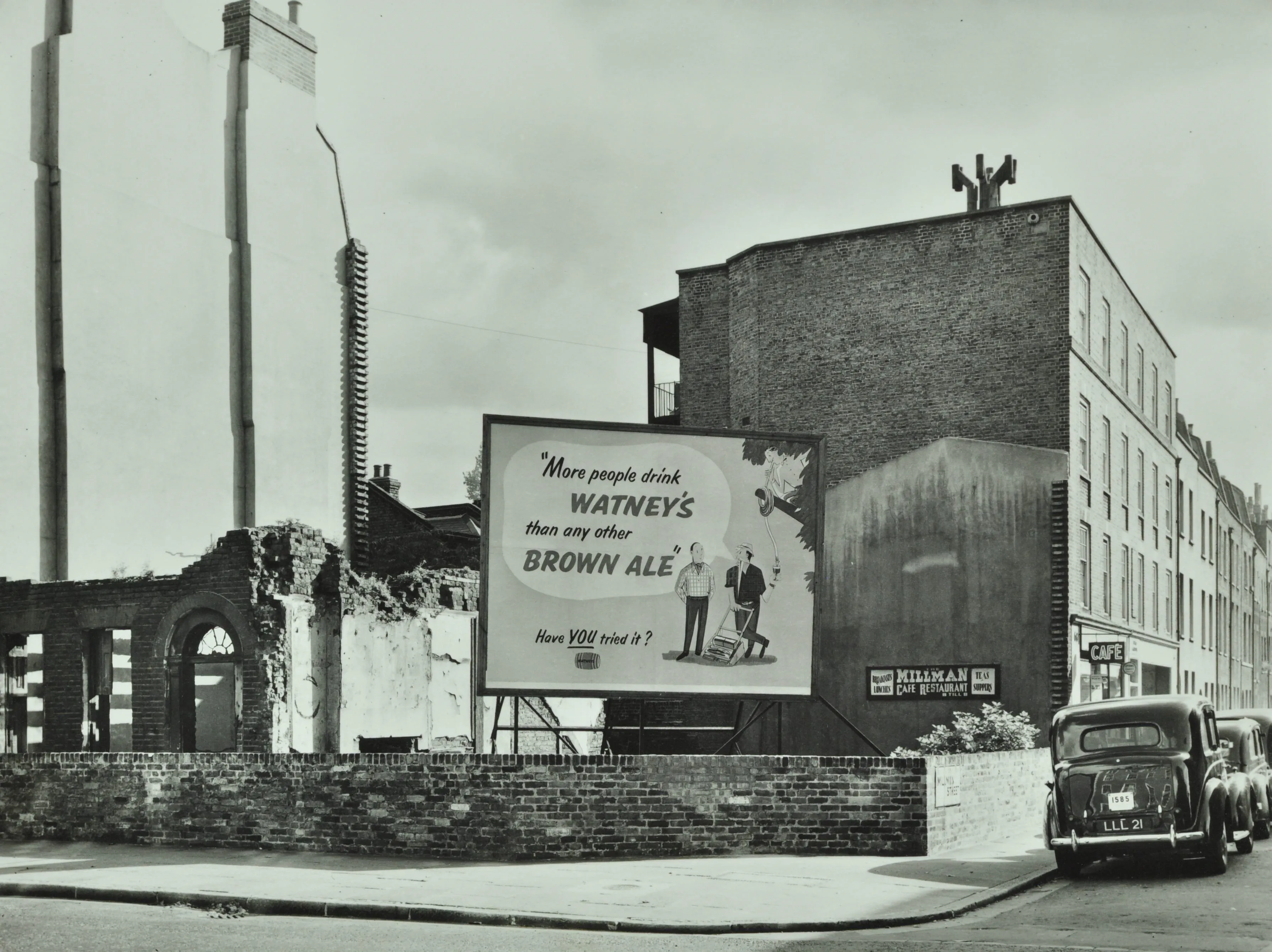 a building in ruins next to a Watney's Brown Ale advert