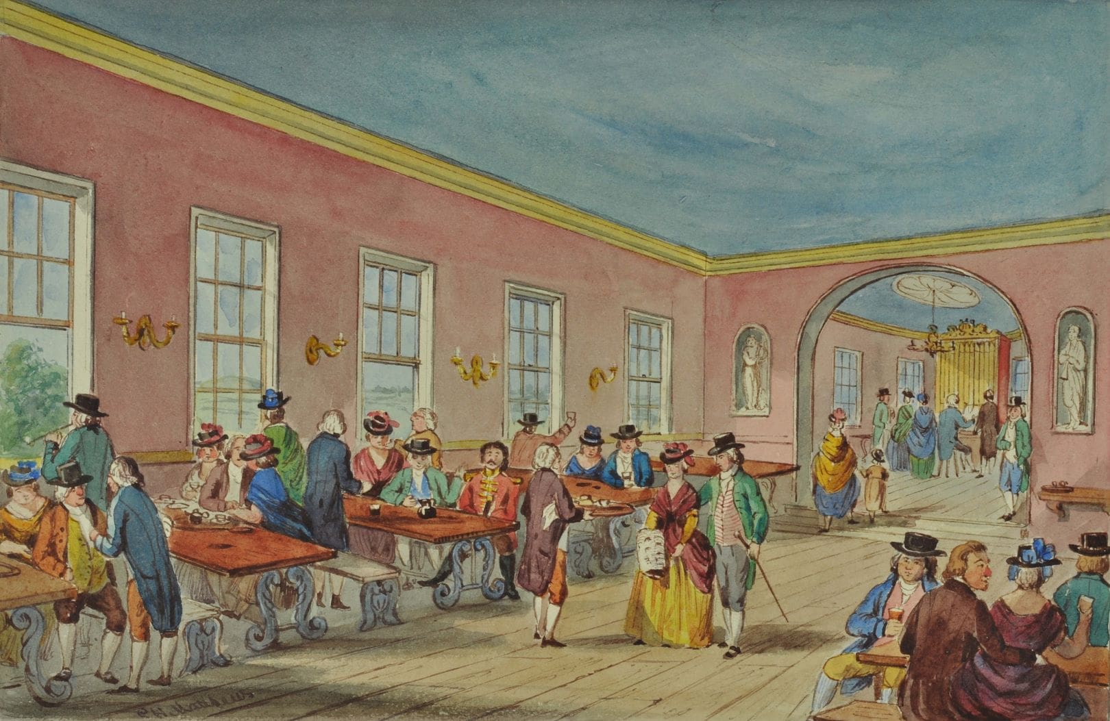 People in a long room with pink walls and blue clothing seated at tables