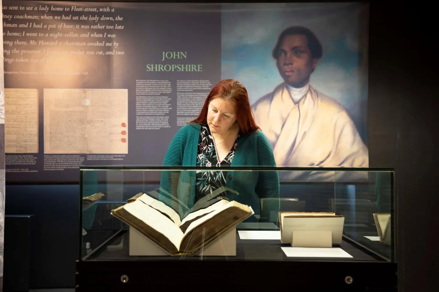A woman viewing the Unforgotten Lives exhibition at The London Archives
