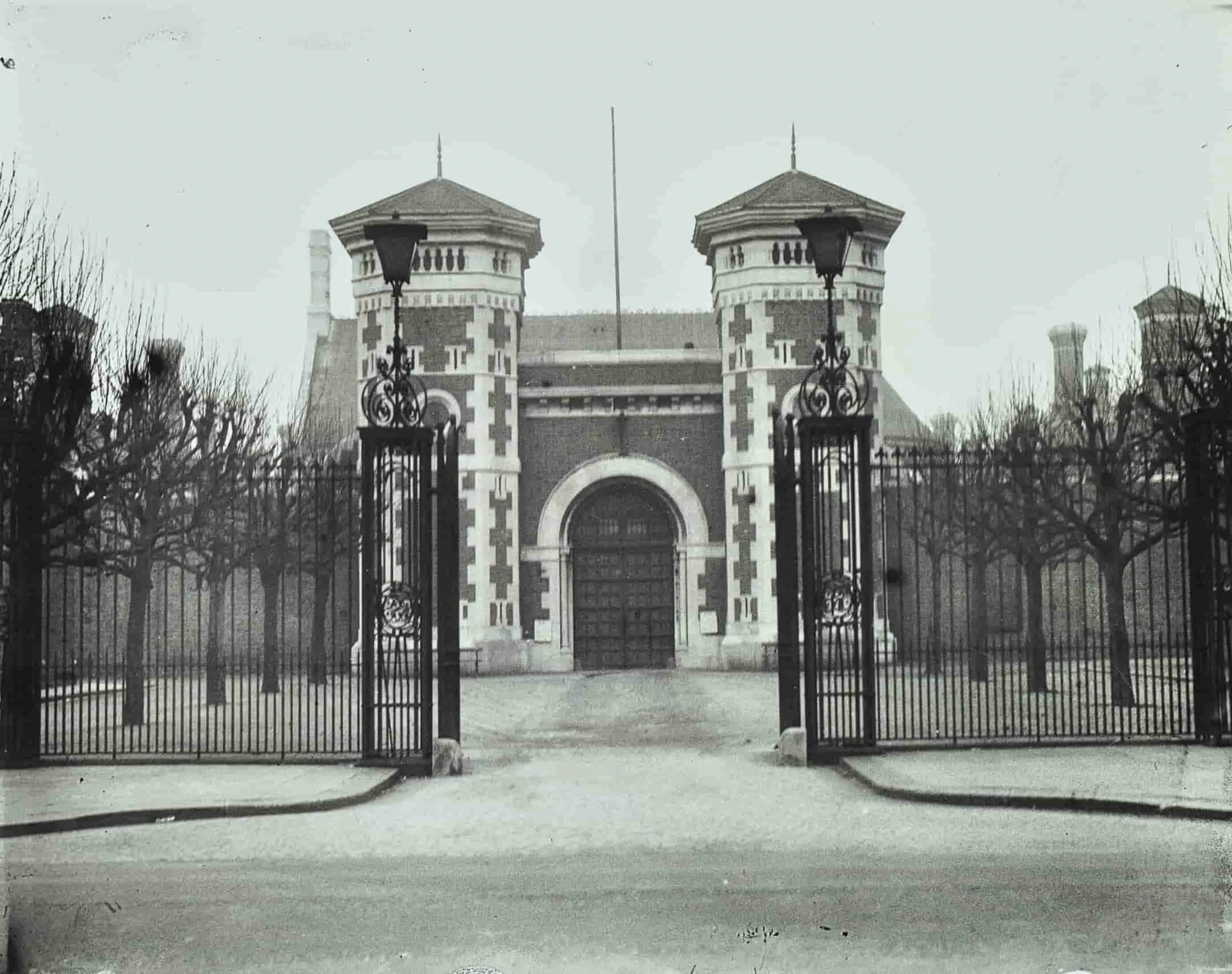 Iron fence and gates in front of towers and large prison doors
